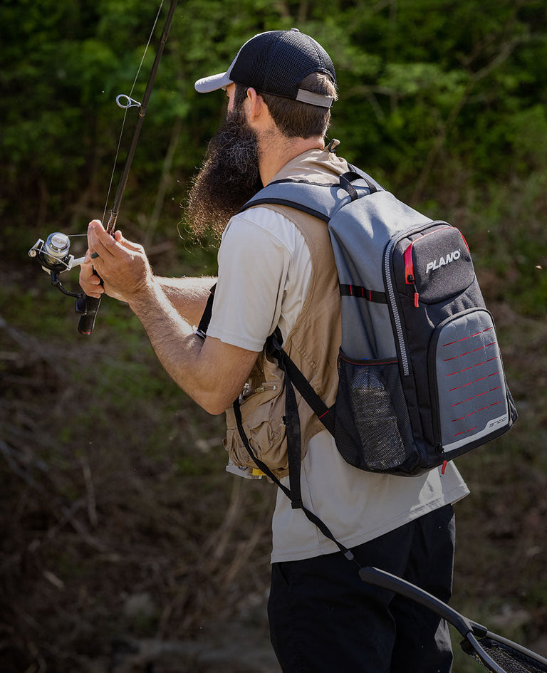 Man fishing with plano tackle backpack on back